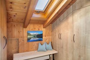 a room with wooden walls and a bench with two pillows at Ferienwohnung Bergkristall in Grainau