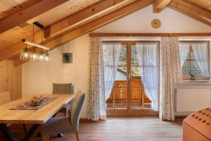 a dining room with a wooden table and a window at Ferienwohnung Bergkristall in Grainau