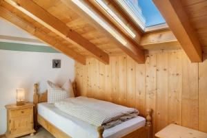 a bedroom with a bed in a room with a skylight at Ferienwohnung Bergkristall in Grainau