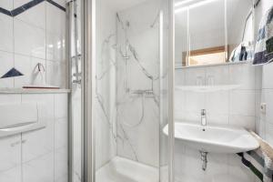 a white bathroom with a shower and a sink at Ferienwohnung Südschwarzwald in Bräunlingen +17 photos