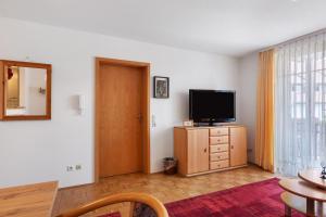a living room with a television on a wooden dresser at Ferienwohnung Südschwarzwald in Bräunlingen