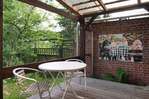 a patio with a table and chairs and a brick wall at Krüseliner Mühle - Appartements in Krüselin