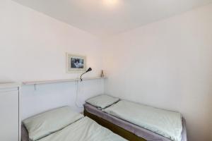 a bedroom with two beds and a lamp on the wall at Möve Aba Appartment 22 in Rerik