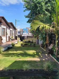 a yard with benches and trees and a fence at Casas Container Cassino in Rio Grande