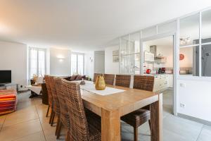 a kitchen and dining room with a wooden table and chairs at Maison de la côte in La Flotte +15 photos