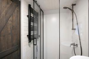 a bathroom with a shower and a glass door at Tiny House Nr 4 in Schwielowsee +25 photos