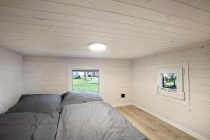 a bed in a small room with a window at Tiny House Nr 4 in Schwielowsee