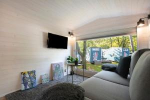 a living room with a couch and a tv at Tiny House Nr 4 in Schwielowsee