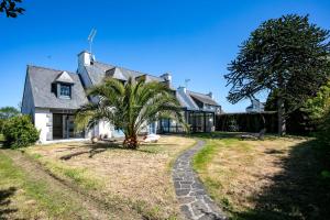 a house with a palm tree in front of it at L'hermine - Villa de charme in Locquirec