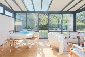 a conservatory with a table and chairs and windows at L'hermine - Villa de charme in Locquirec