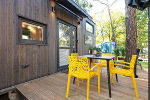 a patio with a table and chairs on a wooden deck at Tiny House Nr 4 in Schwielowsee