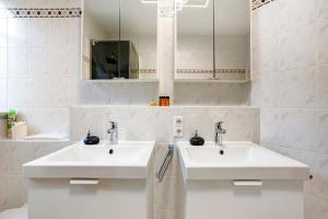 a white bathroom with two sinks and a mirror at Ferienwohnung Flür in Weiler-Simmerberg +20 photos