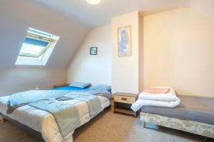 a bedroom with two beds and a window at Gite Terre Mer Des Sables Blancs in Plobannalec-Lesconil