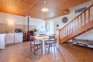 a kitchen and dining room with a table and chairs at Gite Terre Mer Des Sables Blancs in Plobannalec-Lesconil +14 photos