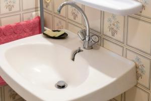 a white sink in a bathroom with a faucet at Gite Terre Mer Des Sables Blancs in Plobannalec-Lesconil