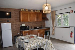 a kitchen with a table and a white refrigerator at Casa Trincadeira in Palmela +11 photos