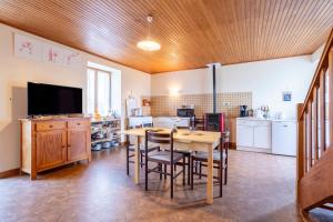 a kitchen with a table and chairs and a television at Gite Terre Mer Des Sables Blancs in Plobannalec-Lesconil