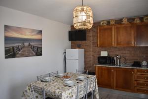 a kitchen with a table with chairs and a white refrigerator at Casa Trincadeira in Palmela