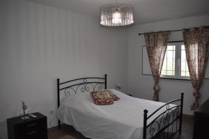 a bedroom with a bed with a pillow and a chandelier at Casa Trincadeira in Palmela