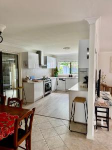 a kitchen with white cabinets and a table and chairs at Garlin Corner in Leggs Island