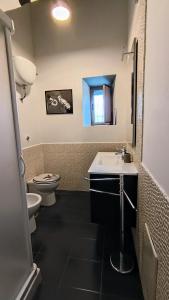 a bathroom with a sink and a toilet and a mirror at Casa baja in Bacoli