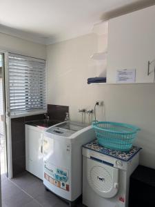 a kitchen with a washing machine and a washer at Garlin Corner in Leggs Island +6 photos