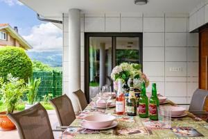 a table with plates and wine bottles on a patio at Casa La Manzana in Villaviciosa
