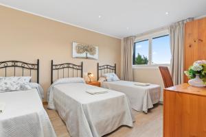 a hotel room with two beds and a window at Casa La Manzana in Villaviciosa