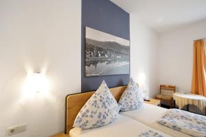 a hotel room with a bed with two pillows at Pension Mosellablick in Briedern