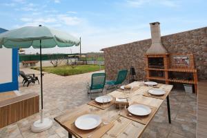 a patio with a wooden table and an umbrella at Bouros's Cliff in Serra do Bouro