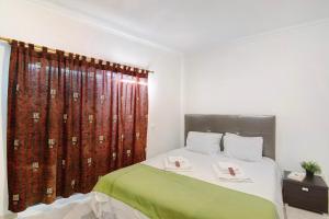 a bedroom with a bed with a green and white blanket at Casa Monte da Balaia in Olhos de Água +16 photos