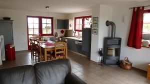 a living room with a couch and a kitchen with a stove at Sabines Badehaus mit Innenpool in Steinkoppel