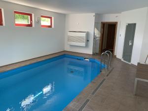 a large blue swimming pool in a room at Sabines Badehaus mit Innenpool in Steinkoppel +16 photos