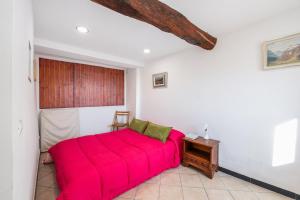 ein Schlafzimmer mit einem roten Bett und einem Tisch in der Unterkunft Tavernetta in campagna in Zoagli
