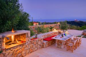 a stone wall with a table and a fireplace at Villa Nautilos Ideales Resort in Kefallonia