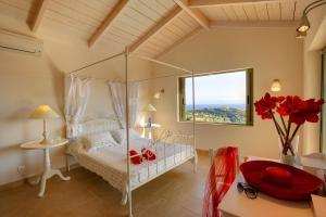 a bedroom with a bed with a glass canopy at Villa Nautilos Ideales Resort in Kefallonia +20 photos