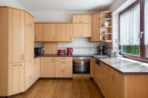 a large kitchen with wooden cabinets and a window at Ferienhaus Christine Bodensee Nord in Pfullendorf