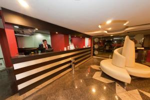 a lobby with a bar with two white chairs at Lagoa Serena Flat Hotel in Araras