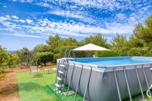 a swimming pool in a yard with an umbrella at Villa Marilor in Salve