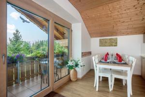 a dining room with a table and a balcony at Martin´s Alm in Friesenried