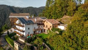 eine Luftaufnahme eines Hauses mit Solarmodulen darauf in der Unterkunft Grotthof in Deutschnofen