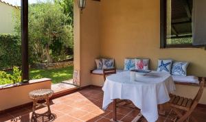 a room with a table and chairs on a patio at Villa Lucia in Costa Rei +17 photos
