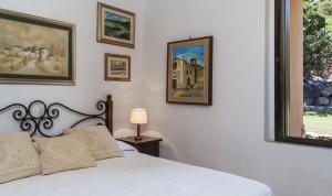 a bedroom with a white bed and pictures on the wall at Villa Lucia in Costa Rei