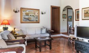 a living room with a couch and a tv at Villa Lucia in Costa Rei