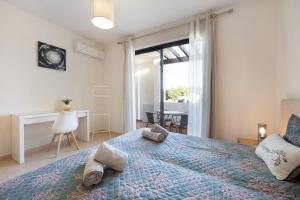 a bedroom with a bed with a blue bedspread at Duo Village in Alvor +21 photos