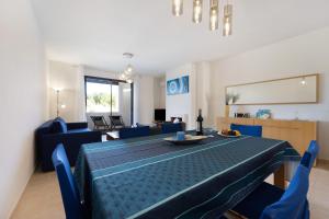 a dining room with a blue table and blue chairs at Duo Village in Alvor