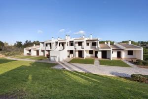 a large white house with a green yard at Duo Village in Alvor