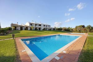 a swimming pool in front of a house at Duo Village in Alvor