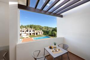 a dining room with a table and chairs and a large window at Duo Village in Alvor