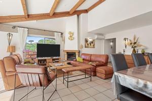 a living room with a couch and a tv at Villa à 200m de la plage in Sainte-Maxime
